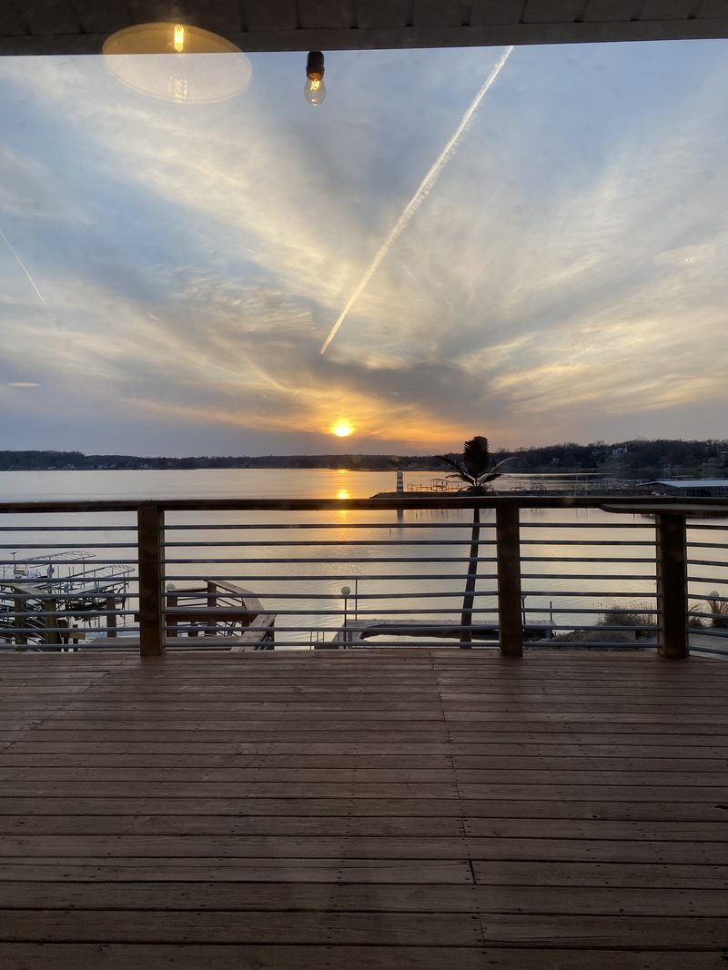Sunset from a covered deck overlooking Lake Panorama and the lighthouse