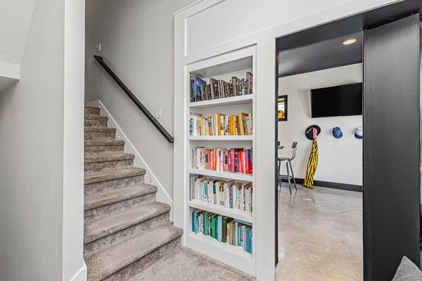 Stairs to the lower level with built-in bookshelves